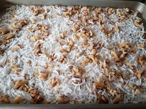 Spread Coconut And Nuts In A Baking Sheet Spread Coconut And Nuts In A Baking Sheet