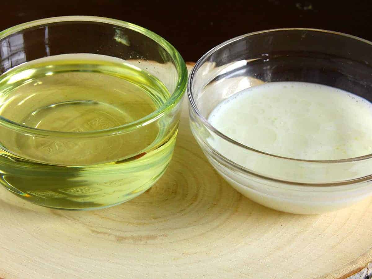 Sunflower oil and milk in a bowl for making eggless mayonnaise at home