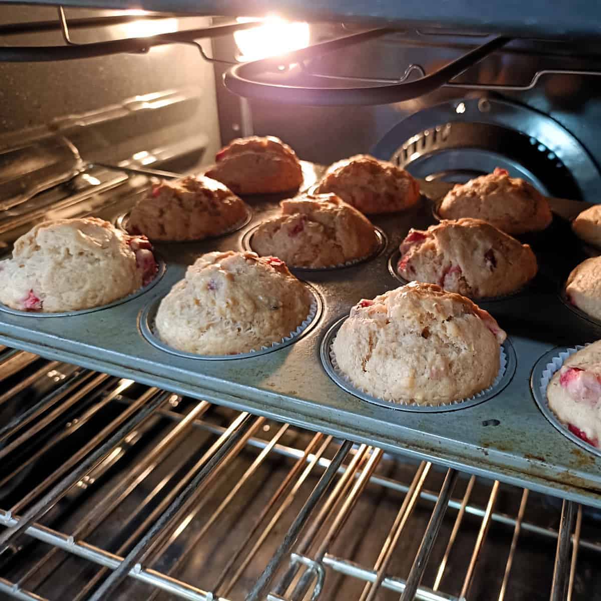 Freshly baked strawberry banana muffins cooling in pan