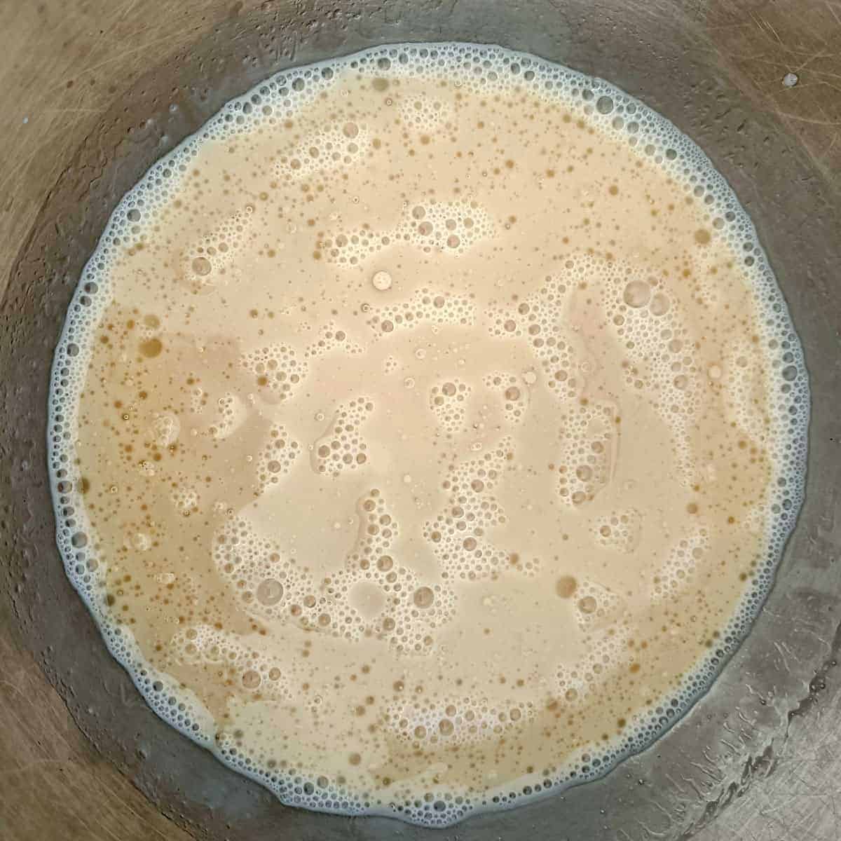 Whisked wet ingredients for eggless waffles in a mixing bowl