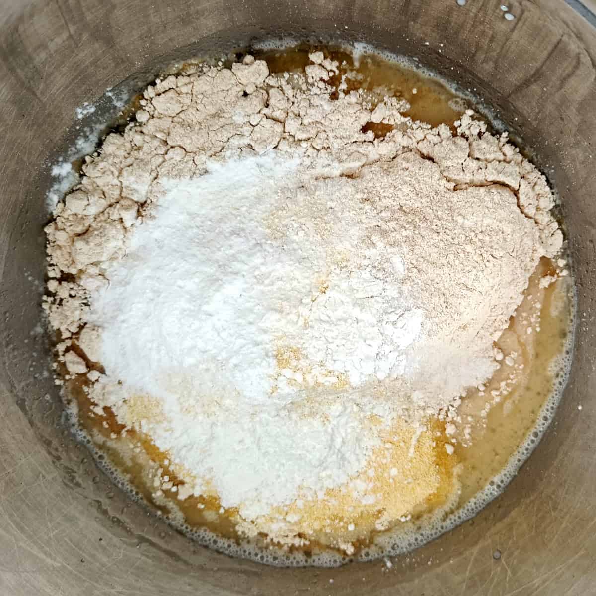 Flour, cornmeal, cornstarch, baking powder, and salt added to wet ingredients for eggless waffles