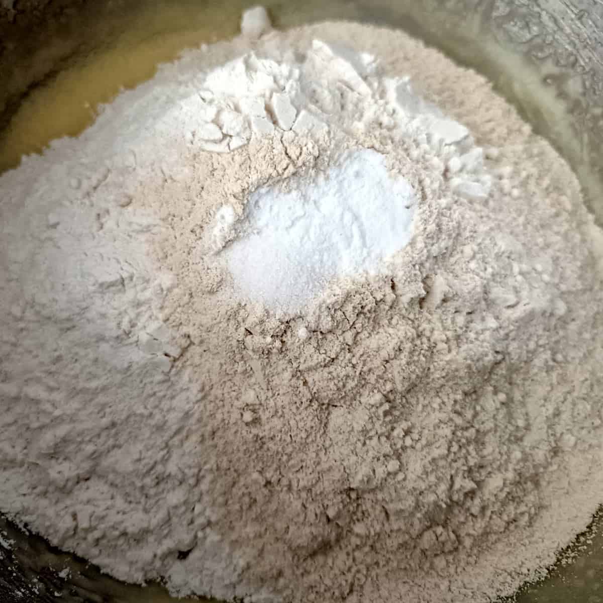 The dry ingredients—flour, baking soda, and salt—are added directly on top of the wet mixture.