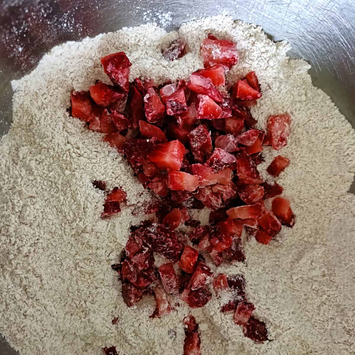 Strawberries folded into flour mixture for strawberry banana muffins