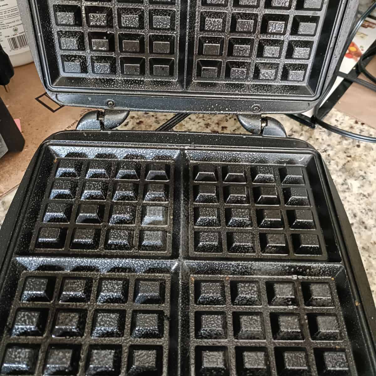 Preheated and greased waffle maker ready for eggless waffle batter