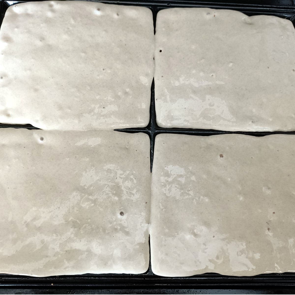 Eggless waffle batter poured into a hot waffle maker before cooking
