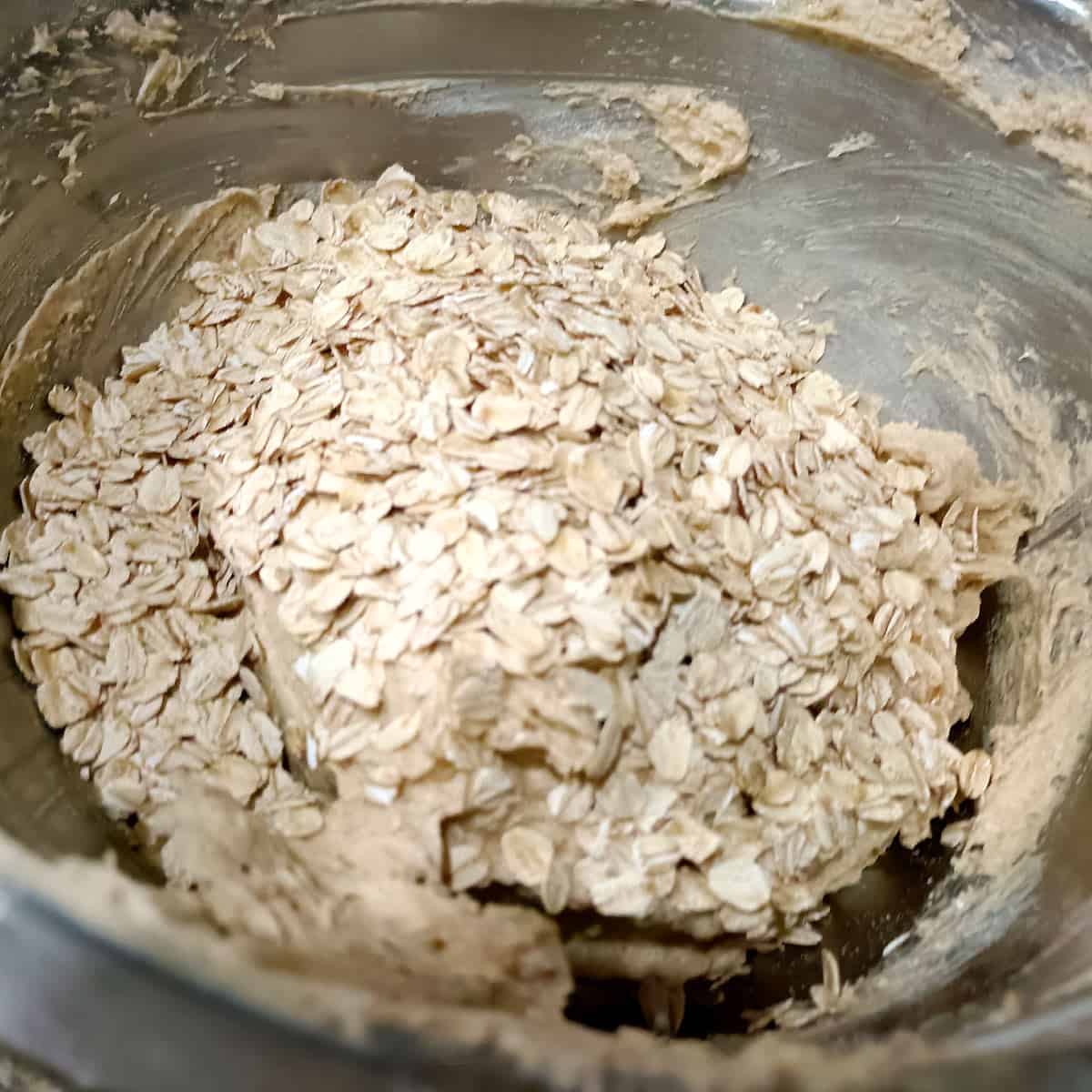 Add oats: Rolled oats are stirred into the dough until evenly distributed.