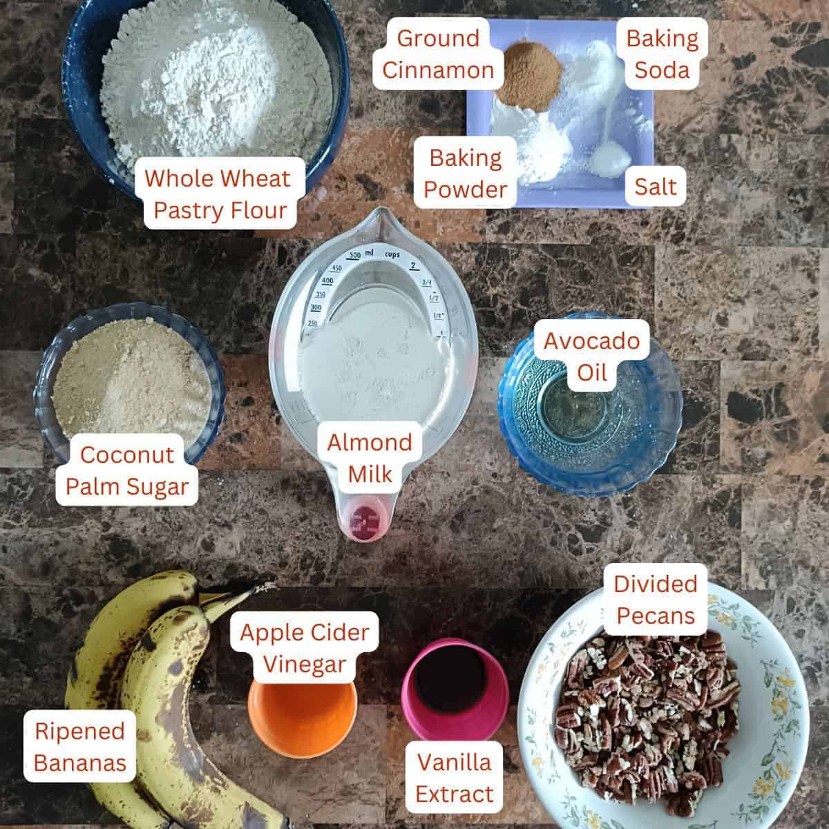 Whole wheat pastry flour, coconut palm sugar, almond milk, avocado oil, ripe bananas, apple cider vinegar, vanilla, pecans, cinnamon, baking powder, baking soda, and salt for vegan banana pecan muffins.