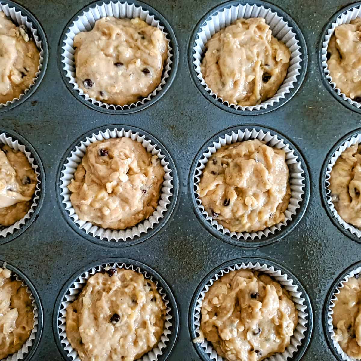 Filling muffin cups with banana chocolate chip batter